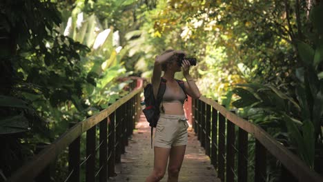 Female-traveler-photographer-taking-photo's-of-beautiful-Cahuita-natural-rainforest-on-boardwalk