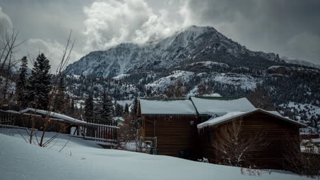 Time-Lapse,-Wooden-Mountain-House-in-Idyllic-White-Snowy-Landscape-With-Clouds,-Moving-Around-Peak