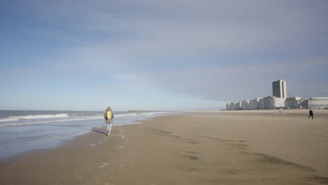 Lone-person-walking-on-the-North-Sea-beach-of-Ostend,-Belgium-coast
