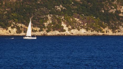 Weißes-Segelboot-Mit-Dingi-Am-Blauen-Ozean-Von-Agia-Kiriaki-Strand-In-Griechenland---Statischer-Schuss