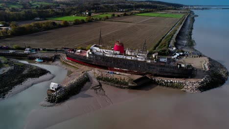 Aerial-View-Of-Abandoned-TSS-Duke-Of-Lancaster-Ship-Near-Mostyn-Docks,-North-Wales---drone-shot