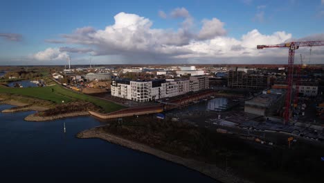 Riverbed-of-river-IJssel-aerial-view-following-a-cloud-passing-casting-a-shadow-and-moving-away-to-reveal-construction-site-of-Kade-Zuid-in-the-Noorderhaven-neighbourhood-formerly-industrial-area