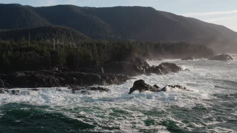 Drone-shot-of-waves-hitting-the-coast-line-at-sunrise-on-Vancouver-Island,-British-Columbia