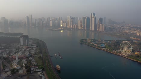 4K:-Drone-view-of-Sharjah's-Khalid-Lake-with-city-skyline-and-Eye-of-Emirates-on-an-early-morning-in-the-United-Arab-Emirates