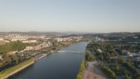 Aerial-view-over-Mondego-River-in-Coimbra-City,-Green-park-on-Riverside