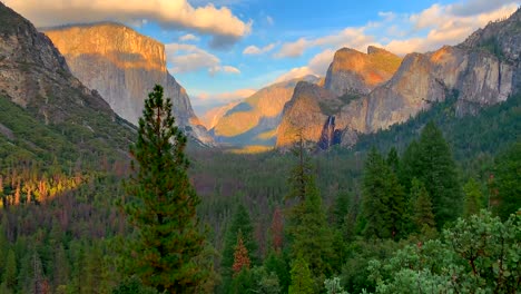 Yosemite-National-Park-surrounded-by-mountains,-trees,-clouds,-and-waterfall