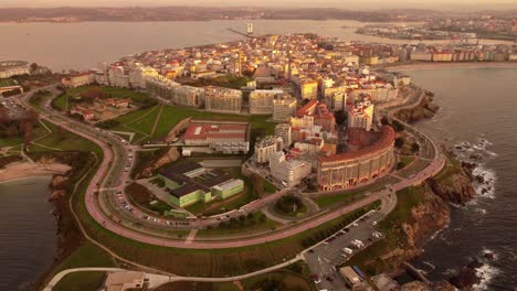 Aerial-view-at-sunset-of-la-coruna-city-in-Galicia-region-north-of-Spain,-view-of-the-urban-residential-district-and-harbor-skyline-and-coastline-seascape