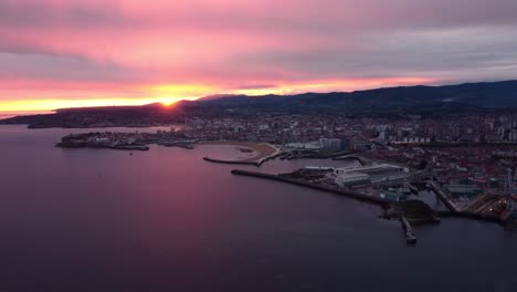 Aerial-cityscape-at-sunset-of-gijon-city-north-of-Spain-commercial-harbor-and-touristic-beach-travel-destination