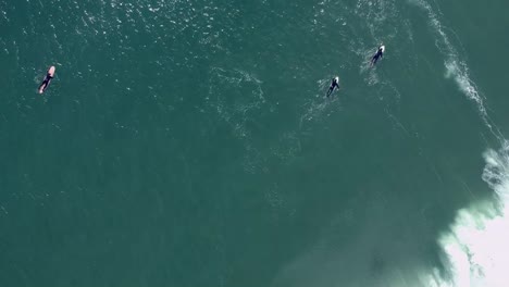 Vista-De-Pedestal-Ascendente-Grupo-De-Surfistas-Atrapando-Olas-En-El-Agua-Fría-Del-Océano-Atlántico