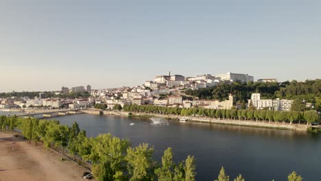 Aerial-view,-Coimbra-ancient-city-panorama-Landscape-through-Mondego-river,-Dolly-shot