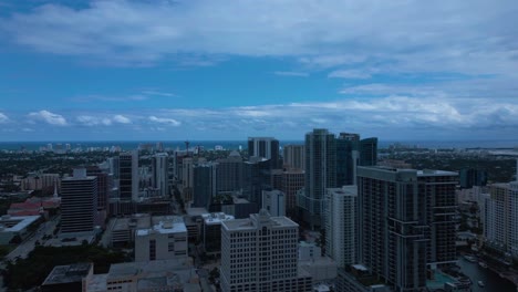 Aerial-drone-shot-of-cityscapes-with-tall-buildings-and-dark-blue-cloudy-sky