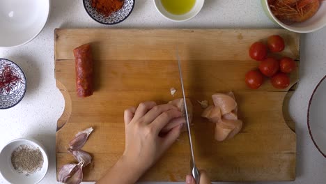 Male-hands-using-knife-to-cut-chicken-breast-into-bite-sized-pieces