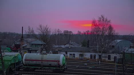 Timelapse-of-dramatic-sunset-over-Bahnhof-,-oil-tank-cars-standing-still-in-the-backyard,-Germany