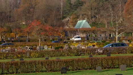 Coches-Circulando-En-El-Cementerio-De-Kviberg-En-Gotemburgo,-Suecia-Durante-La-Temporada-De-Otoño