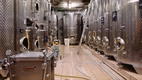 Stainless-steel-tanks-for-fermentation-in-wine-cellar-lined-up