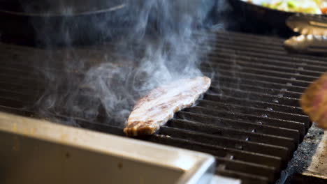 Chef-slaps-raw-slices-of-beef-bulgogi-onto-sizzling-grill-creating-smoke-and-steam,-slow-motion-HD