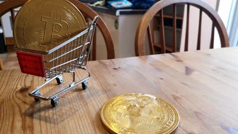 Spinning-golden-bitcoin-crypto-currency-coins-in-tiny-shopping-trolley-on-kitchen-table-concept-rotating-left