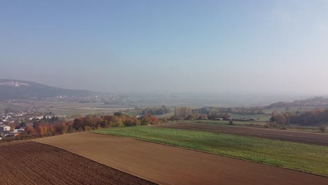Drone-flies-over-fields-in-fog-and-autumn-atmosphere-wirh-blue-sky
