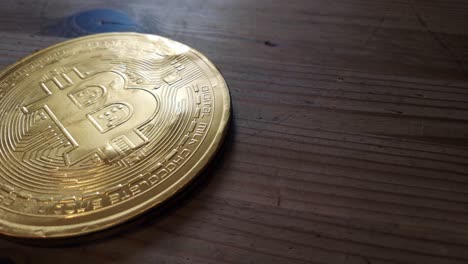 Wrapped-chocolate-gold-bitcoin-crypto-currency-concept-on-wooden-kitchen-table-orbit-right-looking-down