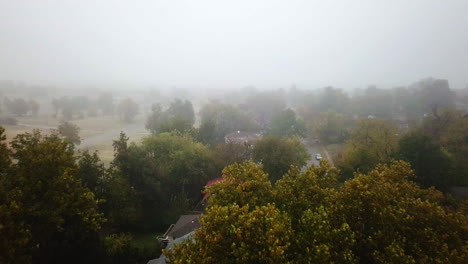 backward-establishing-shot-above-a-residential-area-with-heavy-fog