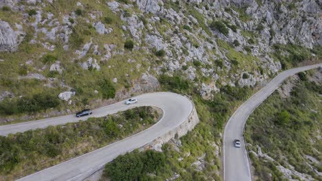 Birdseye-tilted-view-of-a-car-on-a-mountain-road-in-Sa-Calobra,-Mallorca,-Spain-on-a-sunny-afternoon