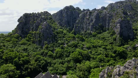 Luftaufnahmen,-Die-Beim-Abstieg-Kalksteinberge-Und-Den-Himmel-Zeigen-Und-Einen-Buddhistischen-Tempel-Und-Den-Wald-Zeigen