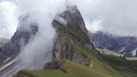 Stunning-cloud-covered-scenic-mountain-at-Puez-Odle-National-Park,-Dolomites,-Italy---Drone-tilt-up-flight