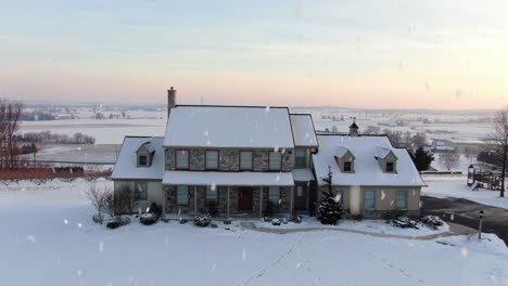 Aerial-establishing-shot-of-family-home-during-winter-snowstorm