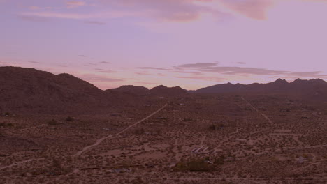 A-gorgeous-sky-at-sunrise-in-Joshua-Tree-with-a-lonely-dirt-road-running-towards-the-jagged-hills