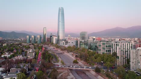 Aerial-view-of-financial-district-in-Santiago-Skyline-by-the-Mapocho-river,-Cerro-El-Plomo-in-Background