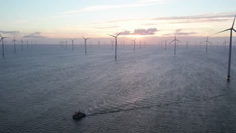 Ship-floating-in-Ijsselmeer-lake-at-Windpark-Friesland-during-sunrise,-aerial