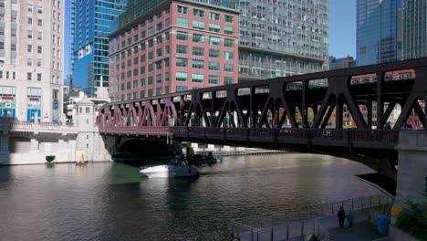 Chicago-River-in-Chicago,-Illinois-with-boat-under-bridge-and-stable-video