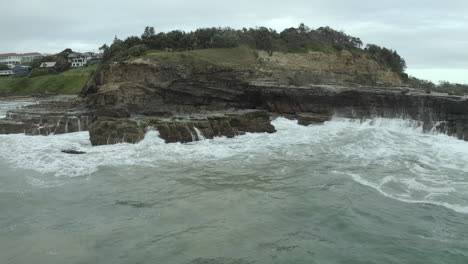 4k-drohnenaufnahme-Von-Meerwasser,-Das-Auf-Felsen-Bei-Yamba,-Australien,-Abstürzt