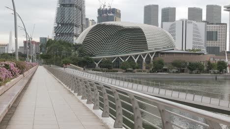 Vista-De-La-Pasarela-A-Lo-Largo-Del-área-De-La-Bahía-Del-Puerto-Deportivo-Con-Torre-De-Edificio-Financiero-De-Oficinas-De-Rascacielos-De-Gran-Altura-En-El-Distrito-Central-De-Negocios-De-La-Ciudad-De-Singapur,-Moderno-Edificio-Del-Centro-De-La-Ciudad-De-Metrópolis