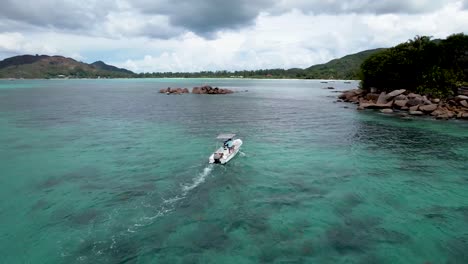 Luftaufnahme-Eines-Weißen-Bootes,-Das-In-Richtung-Einer-Kleinen-Felseninsel-Auf-Den-Seychellen-Fährt
