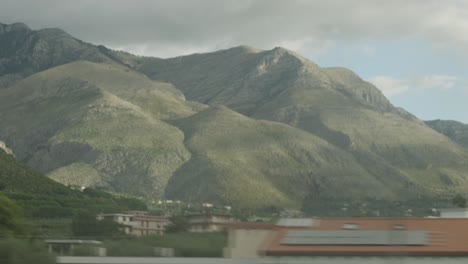 Traveling-On-A-Train-Passing-By-Majestic-Mountains-In-Italy