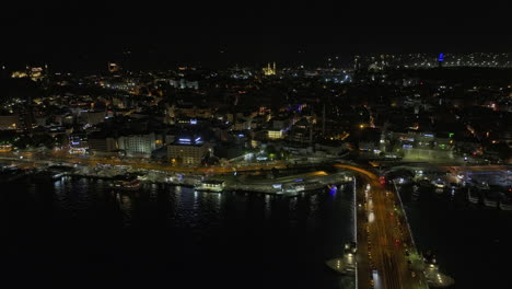 Istanbul-Turkey-Aerial-v20-low-level-flyover-golden-horn-along-galata-bridge-capturing-traffic-crossing-and-downtown-cityscape-of-eminönü-neighborhood-at-night---Shot-with-Mavic-3-Cine---July-2022