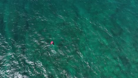 Wing-foiler-cruising-wide-open-clear-turquoise-Hawaiian-waters,-Hookipa-overhead