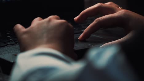 Close-up-of-person-typing-wit-hand-on-keyboard-of-laptop-at-night-at-home