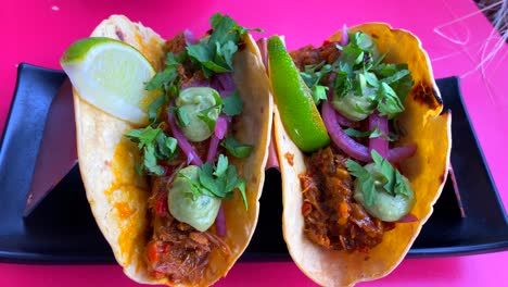 Leckere-Al-Pastor-Tacos-Mit-Fleisch,-Eingelegten-Roten-Zwiebeln,-Koriander,-Guacamole-Und-Limette,-4k-Shot