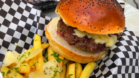 Saftiger-Cheeseburger-Mit-Cheddar-Käse,-Pommes-Frites-Und-Ketchup,-Fast-Food-Restaurant,-4k-Zoom-In-Aufnahme
