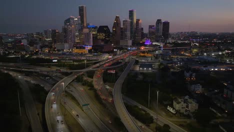 Luftaufnahme-In-Richtung-Der-Beleuchteten-Skyline-Von-Houston-City,-Dämmerung-In-Texas,-Usa