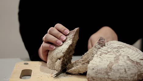 cutting-bread-with-a-bread-knife-in-the-kitchen-with-people-stock-videos-stock-footage