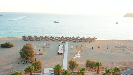 Luftaufnahme-Milopotas-Tropischer-Strand,-Menschen,-Die-Bei-Sonnenuntergang-Auf-Sand-Volleyball-Spielen,-Griechenland