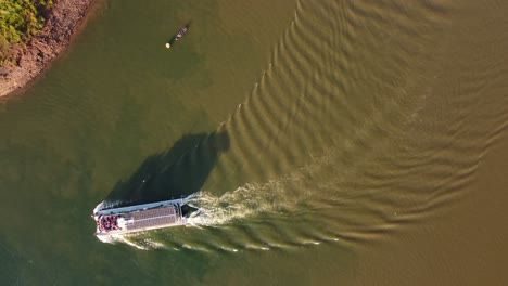 Luftaufnahme-Eines-Touristenbootes,-Das-Bei-Sonnenuntergang-Am-Fluss-Iguazu-An-Der-Grenze-Zwischen-Argentinien-Und-Brasilien-In-Südamerika-Anlegt