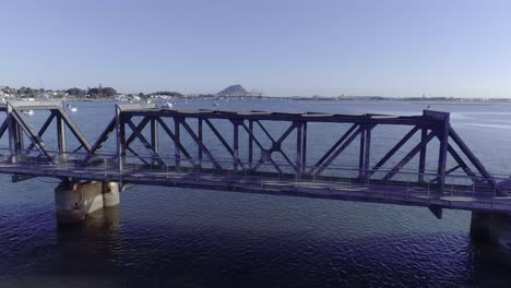 Matapihi-steel-truss-railroad-bridge-crossing-water-bay-in-Tauranga,-Bay-of-Plenty,-aerial