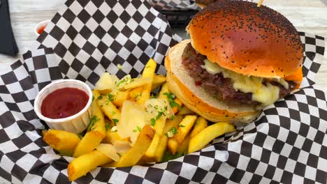 Saftiger-Cheeseburger-Mit-Cheddar-Käse,-Pommes-Frites-Und-Ketchup,-Fast-Food-Restaurant,-4k-Aufnahme