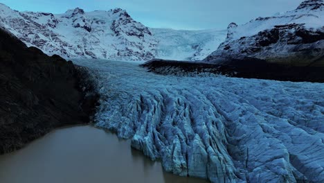 Luftaufnahme-Des-Svinafellsjökull-gletschers-Mit-Tiefen-Spalten-In-Island,-Umgeben-Von-Schneebedeckten-Bergen