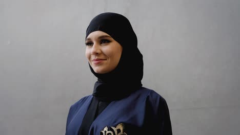 Close-up-of-female-on-Hijab-Abaya-at-an-outdoor-business-location,-with-her-own-reflection-wearing-traditional-women's-clothing