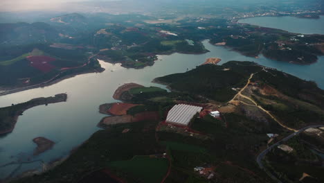 Lago-Vietnamita-Con-Pequeños-Pueblos-Y-Edificios-Alrededor,-Vista-De-Drones-A-Gran-Altura